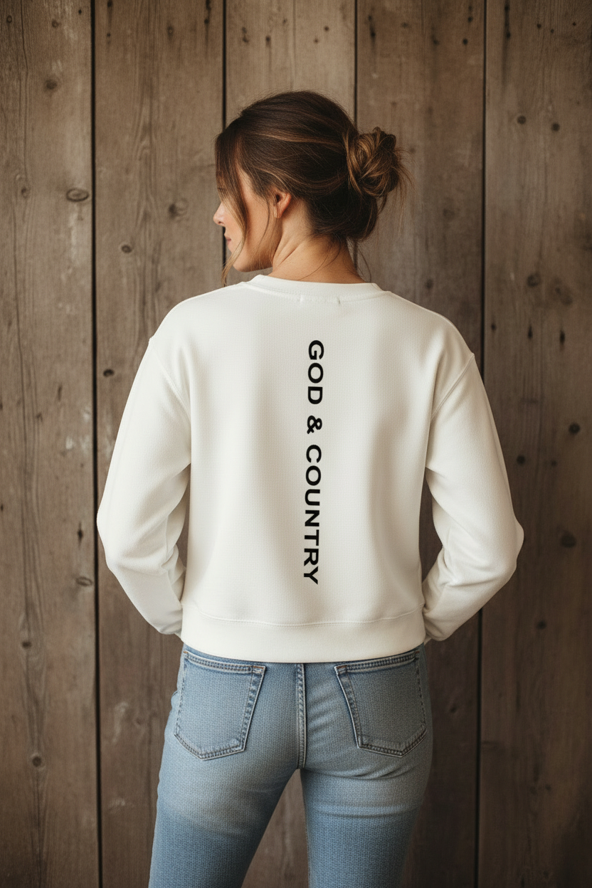 Back view of female model wearing white cropped G&C crewneck against rustic wood