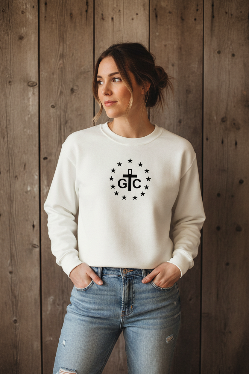 Female model wearing white cropped G&C crewneck against rustic wood